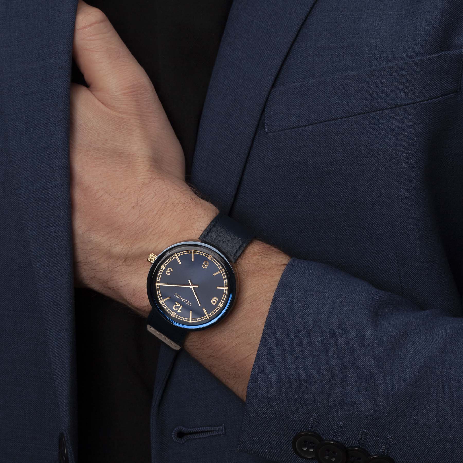 Man in blue suit wearing blue and gold watch. Vejrhøj
