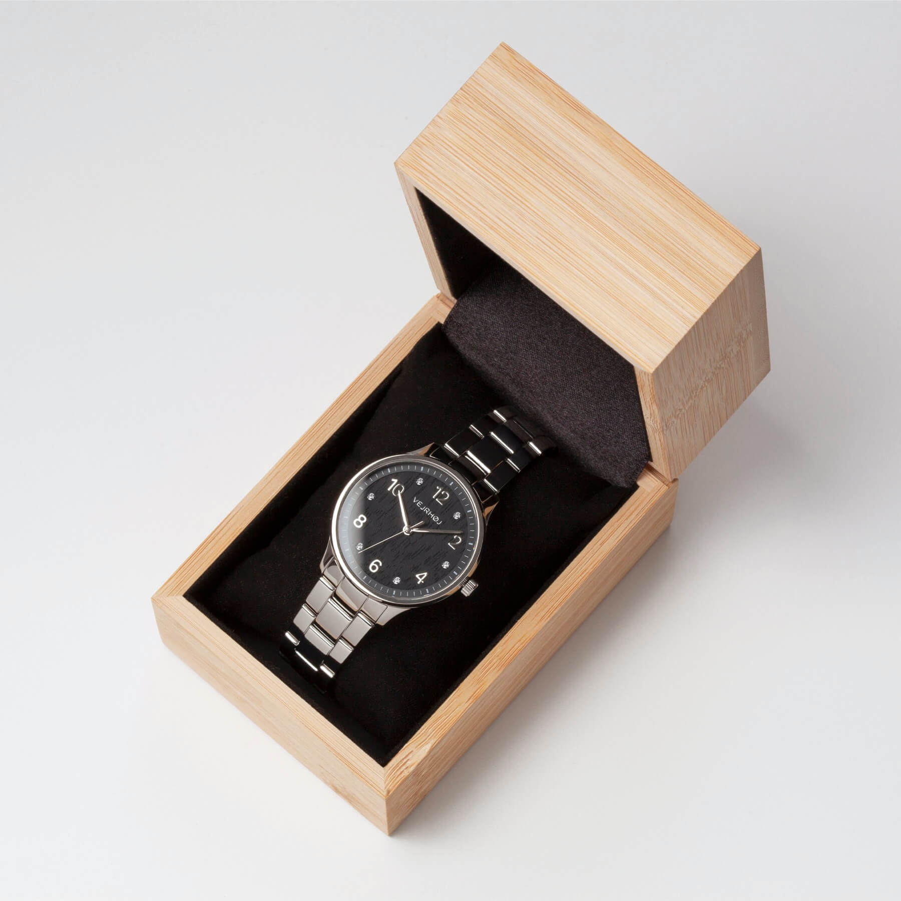 Vejrhøj Petite Royal Black, a beautiful ladies watch with a black wood grain dial and silver bracelet in a special natural bamboo box. 
VEJRHØJ's Petite Royal Black, a black wood grain face that looks like it blends in with the grass and flowers in natural light. Ladies' watch