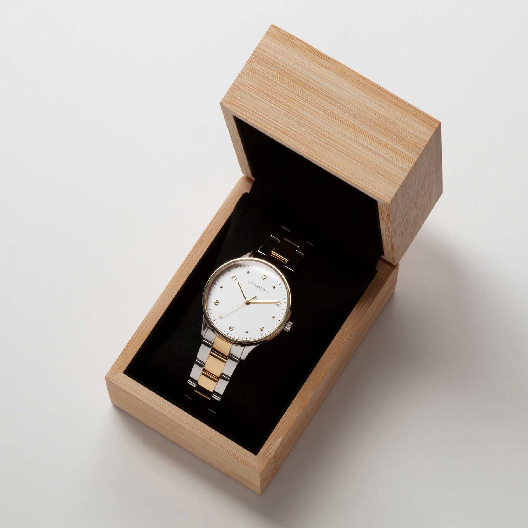 Vejrhøj's Petite Royal Gold, watch with gold and silver combination bracelet and white dial. Elegant packaging photo in a bamboo gift box.