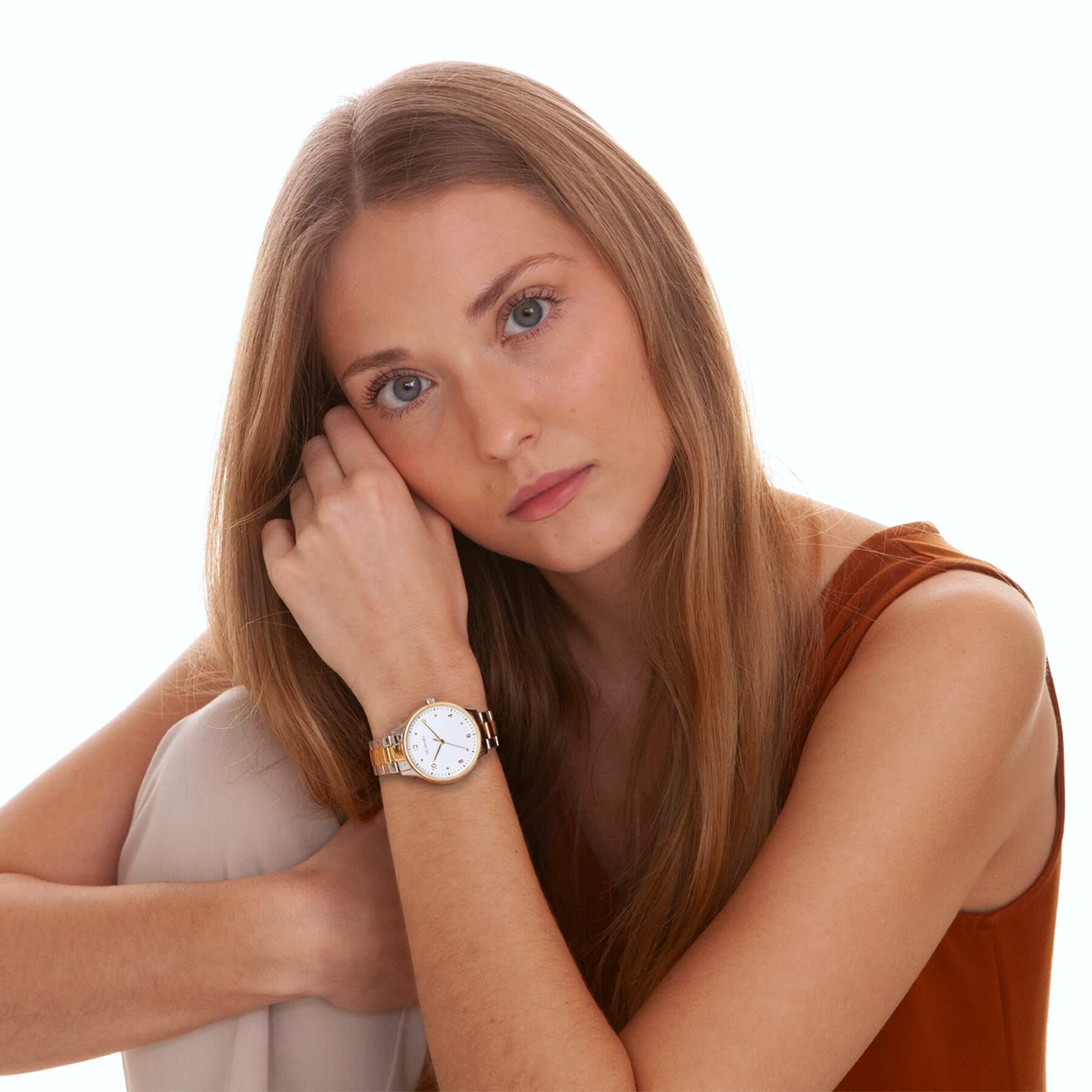 Woman wearing a white gold watch on her wrist with a neutral background
