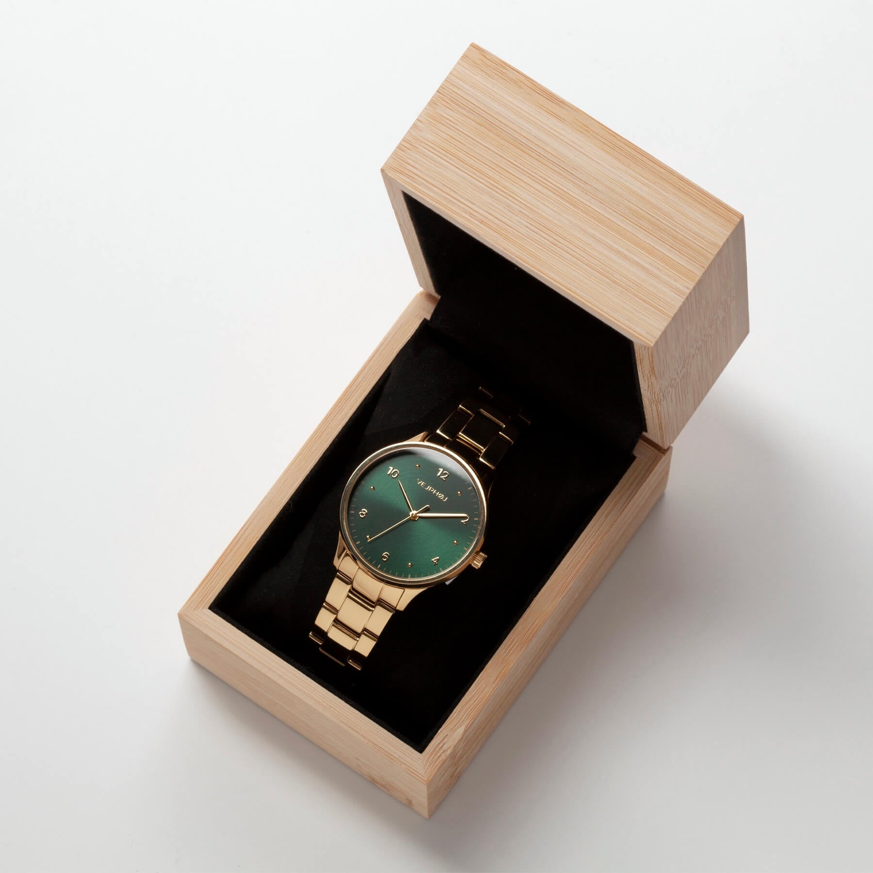 VEJRHØJ's Petite Royal Green, a Scandinavian design watch with a green dial and gold case that harmonizes with elegant outfits, in a special bamboo box