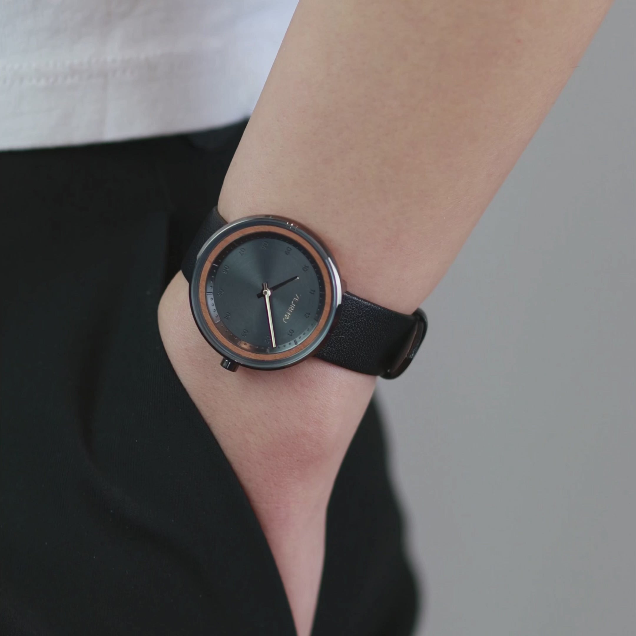 Black watch with wooden ring being showcased by a person wearing it