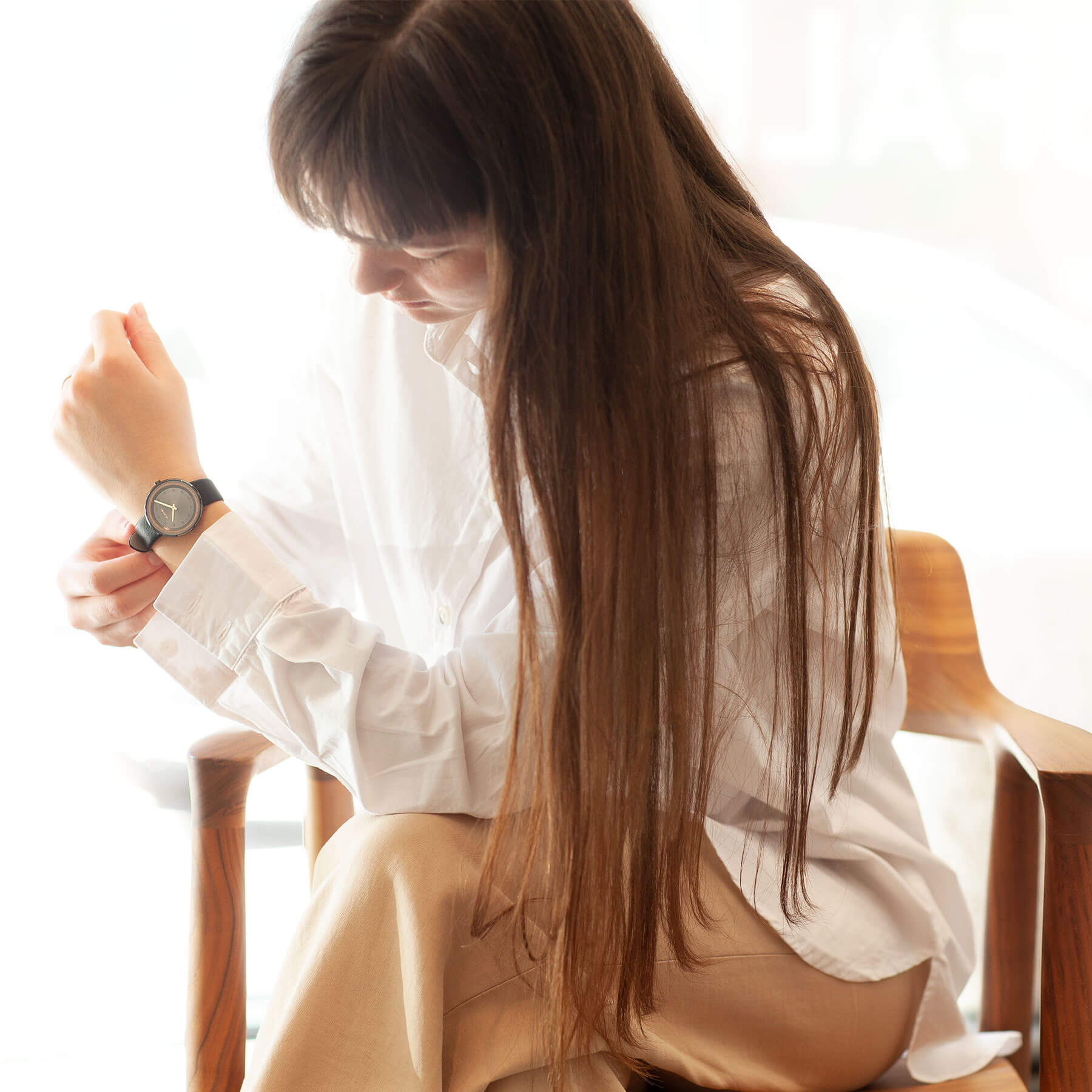 Woman wearing a black watch with a wooden ring