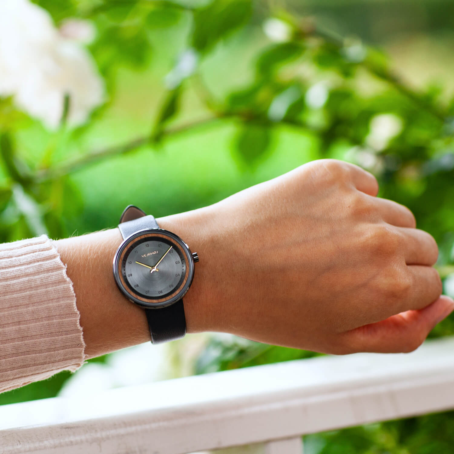 Black watch with greenery as background